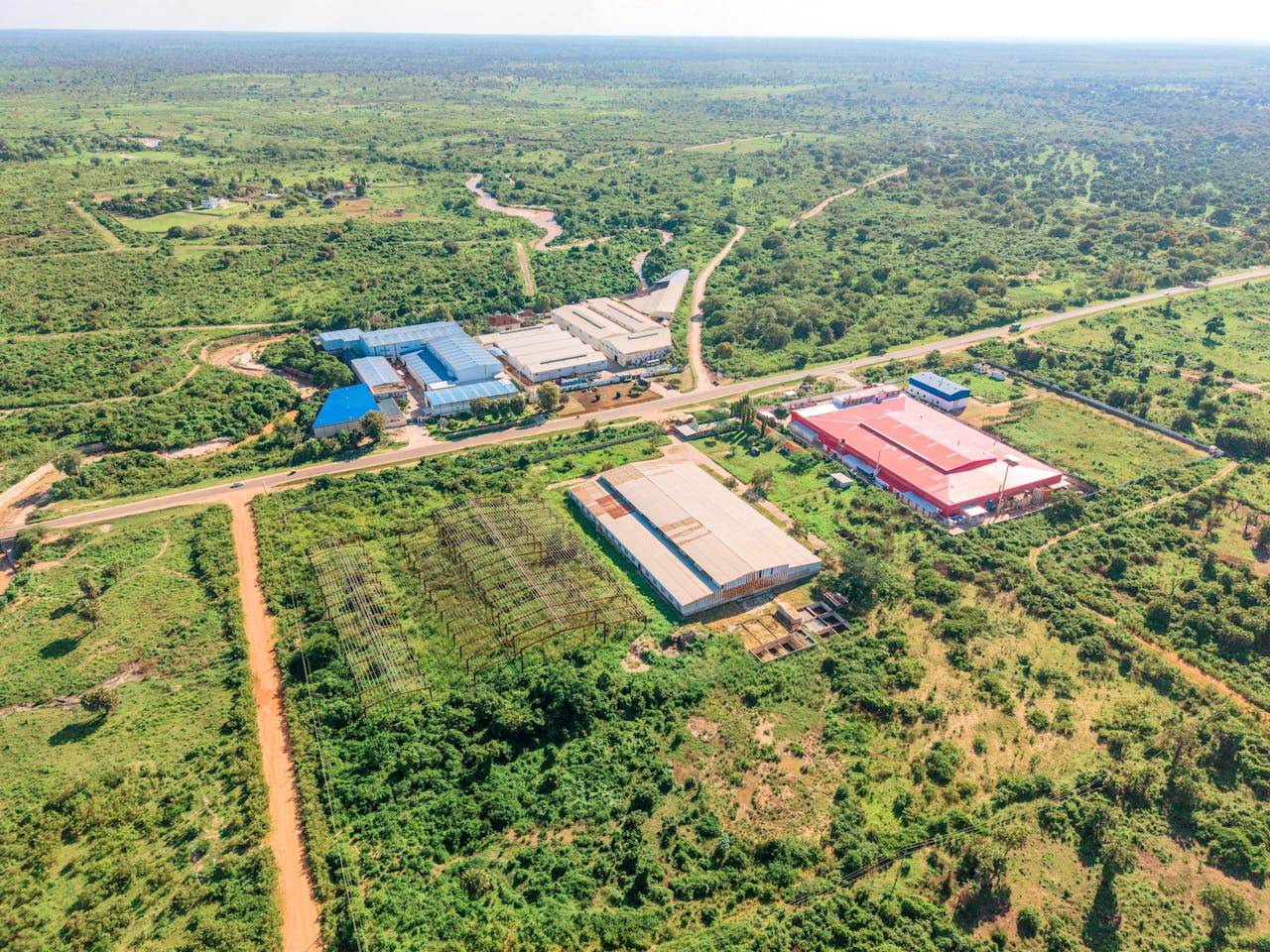 Aerial view showcasing industrial warehouses surrounded by green landscape.
